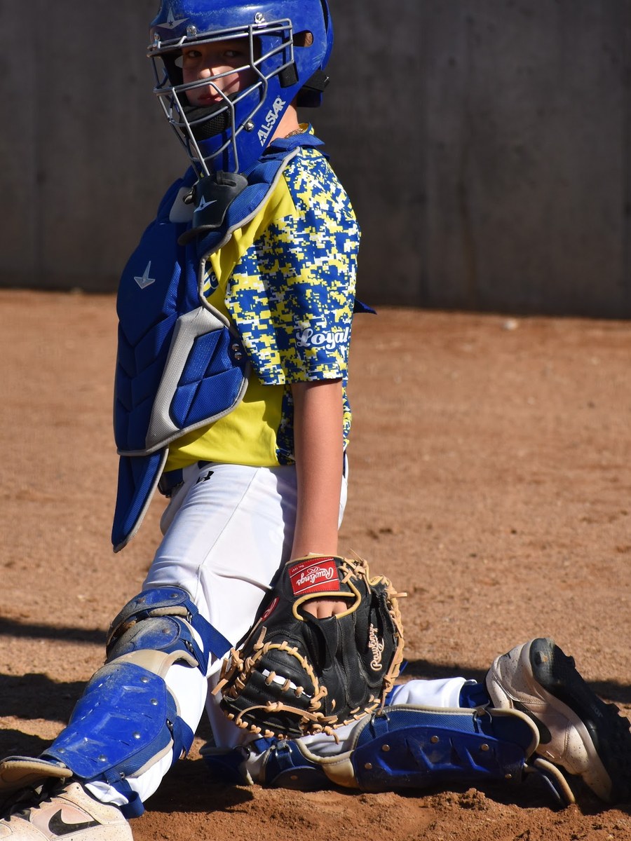 A Canyon Lakers catcher in full gear down in his stance