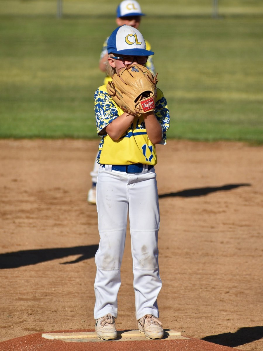 A Canyon Lakers pitcher on the mound reading the sign