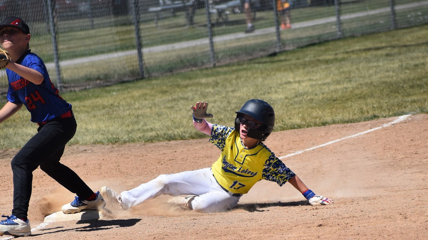 A Canyon Lakers runner sliding into the bag ahead of the throw